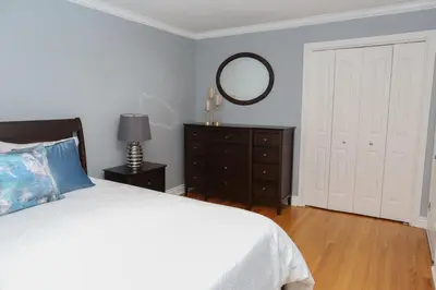 a bedroom with a bed with a mirror and a dresser at Appartement 3 chambres avec SOUS-SOL in Laval