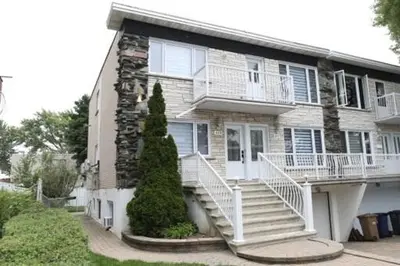 a large house with stairs in front of it at Appartement 3 chambres avec SOUS-SOL in Laval