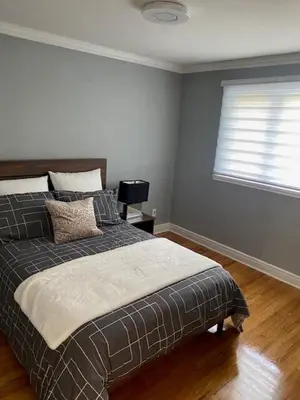 a bedroom with a large bed with a window at Appartement 3 chambres avec SOUS-SOL in Laval