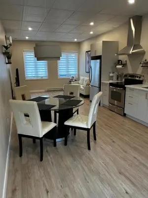 a kitchen and dining room with a table and chairs at Comme chez soi in Granby