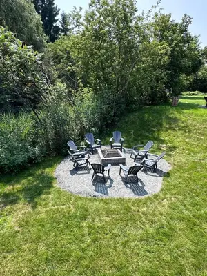 a group of chairs and a picnic table in the grass at Comme chez soi in Granby