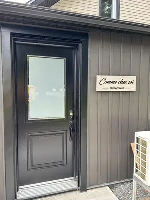 a door to a house with a sign on it at Comme chez soi in Granby