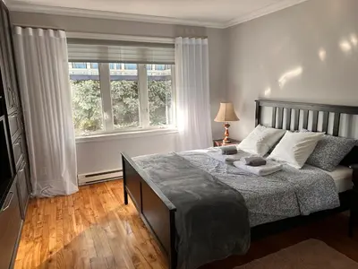 a bedroom with a bed and a large window at Vieux Beloeil appartement free Parking in Beloeil Village