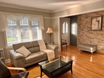 a living room with a couch and a brick wall at Vieux Beloeil appartement free Parking in Beloeil Village