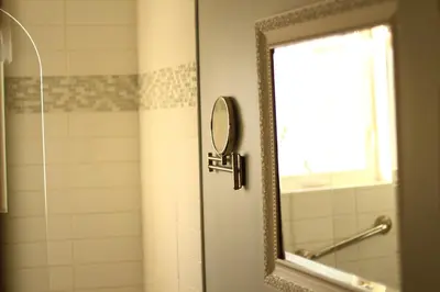 a bathroom with a mirror and a shower at Vieux Beloeil appartement free Parking in Beloeil Village