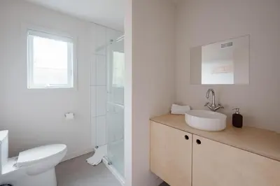a white bathroom with a toilet and a sink at Chalets OST Shefford FORFAIT GROUPE in Shefford