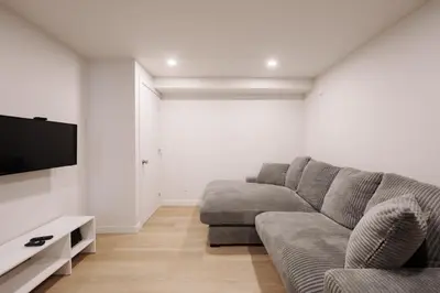 a living room with a couch and a flat screen tv at Chalets OST Shefford FORFAIT GROUPE in Shefford