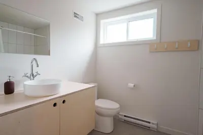 a bathroom with a sink and a toilet and a window at Chalets OST Shefford FORFAIT GROUPE in Shefford