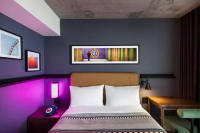 a bedroom with a bed with purple lighting at Moxy Montreal Downtown in Montréal