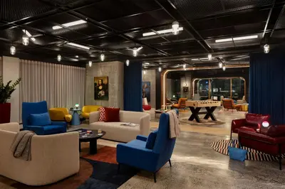 a living room with couches and chairs and a table at Moxy Montreal Downtown in Montréal