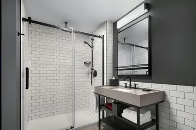 a bathroom with a sink and a shower with a mirror at Moxy Montreal Downtown in Montréal