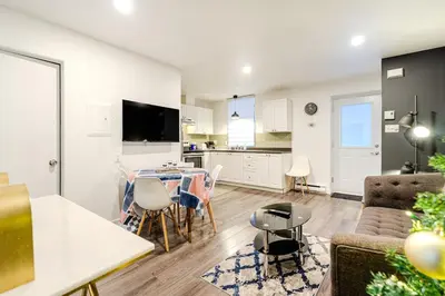 a living room and kitchen with a table and chairs at Bright stay in Griffin Town in Montréal