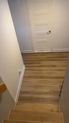 a hallway with a white door and wooden floors at Cozy Terrebonne in Terrebonne
