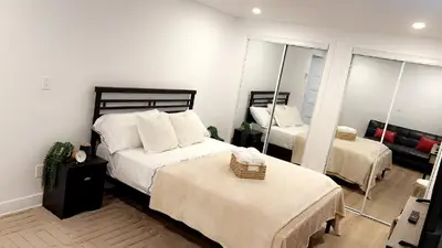 a bedroom with two beds and a mirror at Cozy Terrebonne in Terrebonne