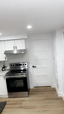 a kitchen with a stove and white cabinets at Cozy Terrebonne in Terrebonne