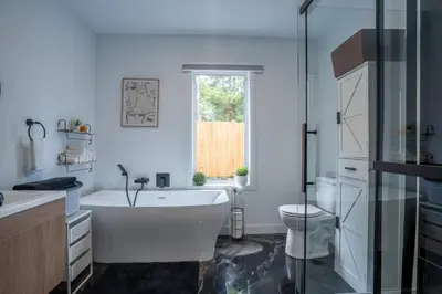a bathroom with a tub and a sink and a toilet at L'Étoile Brillante, Spa, River, Pool Table in La Patrie