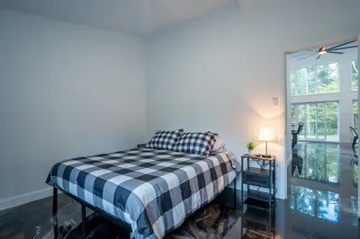 a bedroom with a bed with a checkered blanket at L'Étoile Brillante, Spa, River, Pool Table in La Patrie