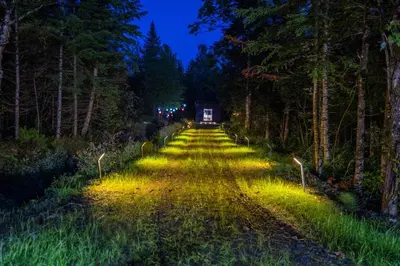 a road in the middle of a forest at night at L'Étoile Brillante, Spa, River, Pool Table in La Patrie