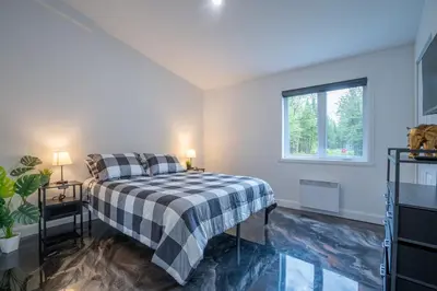 a bedroom with a bed with a checkered blanket at L'Étoile Brillante, Spa, River, Pool Table in La Patrie