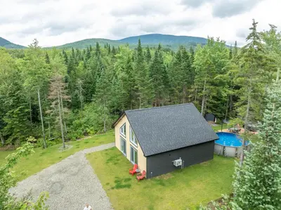 an aerial view of a tiny house with a swimming pool at Chalet Escapade, Spa, Piscine in La Patrie