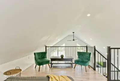 a living room with two green chairs and a table at Chalet Escapade, Spa, Piscine in La Patrie