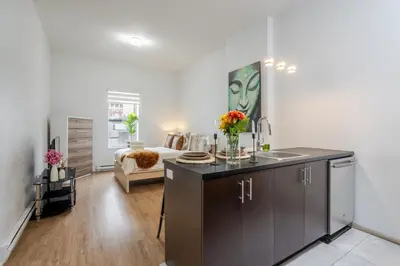 a kitchen with a sink and a living room at Cute Studio on Bishop - Hot Spot Dtown MTL in Montréal