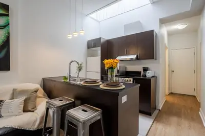 a kitchen and living room with a couch and a counter at Cute Studio on Bishop - Hot Spot Dtown MTL in Montréal
