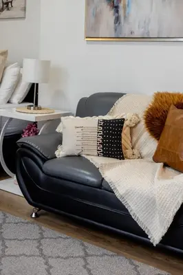 a black leather couch sitting in a living room at Snug Studio on Bishop DT MTL in Montréal