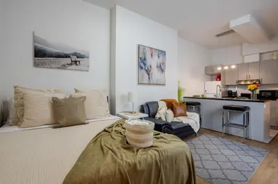 a living room with a table and a kitchen at Snug Studio on Bishop DT MTL in Montréal