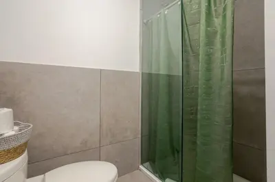 a bathroom with a shower curtain and a toilet at Snug Studio on Bishop DT MTL in Montréal