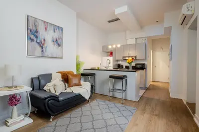 a living room with a couch and a kitchen at Snug Studio on Bishop DT MTL in Montréal