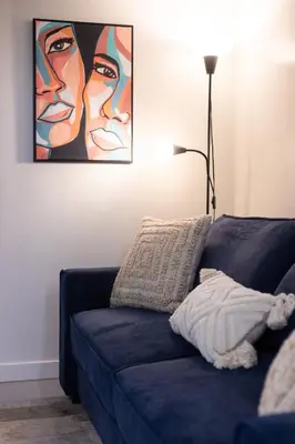 a blue couch in a living room with a painting at Stylish 4BR in the heart of Plateau Montreal in Montréal