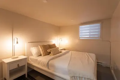 a bedroom with a bed with two lamps and a window at Stylish 4BR in the heart of Plateau Montreal in Montréal