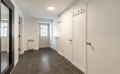 a hallway with white walls and a tile floor at Au coeur du plateau!! in Montréal