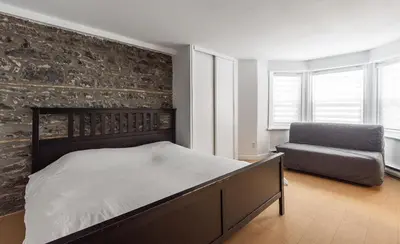 a bedroom with a bed and a chair at Au coeur du plateau!! in Montréal