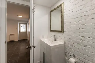a bathroom with a sink and a white brick wall at Au coeur du plateau!! in Montréal