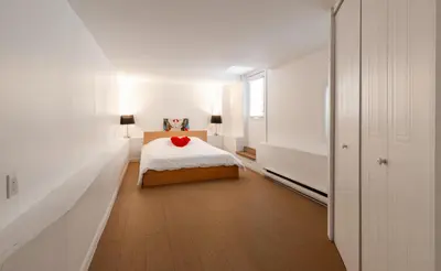 a bedroom with a bed with a red pillow on it at Au coeur du plateau!! in Montréal