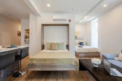 a bedroom with a bed and a couch at Inner-City Studio on Bishop -Heart of MTL in Montréal