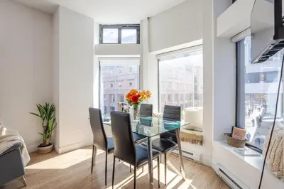 a dining room with a glass table and chairs at Inner-City Studio on Bishop -Heart of MTL in Montréal
