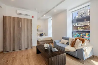 a living room with a couch and a bed at Inner-City Studio on Bishop -Heart of MTL in Montréal