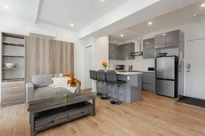 a kitchen and living room with a couch and a table at Modern Studio on Bishop - Spotlight MTL in Montréal