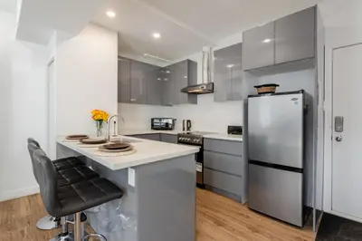 a kitchen with a stainless steel refrigerator and a counter at Modern Studio on Bishop - Spotlight MTL in Montréal