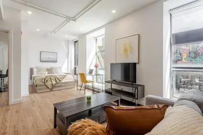 a living room with a couch and a tv at Modern Studio on Bishop - Spotlight MTL in Montréal