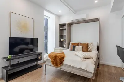 a living room with a tv and a couch at Modern Studio on Bishop - Spotlight MTL in Montréal