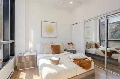 a bedroom with two beds and a large window at Cute 1BDR Apt on Bishop St- Heart of MTL in Montréal