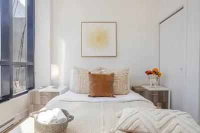 a bedroom with a bed and a picture on the wall at Cute 1BDR Apt on Bishop St- Heart of MTL in Montréal