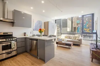 a kitchen and living room with a couch at Cute 1BDR Apt on Bishop St- Heart of MTL in Montréal