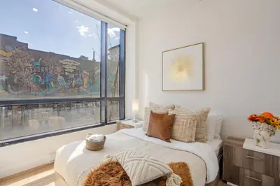 a bedroom with a bed and a large window at Cute 1BDR Apt on Bishop St- Heart of MTL in Montréal