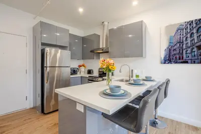 a kitchen with a table and a refrigerator at Cute 1BDR Apt on Bishop St- Heart of MTL in Montréal