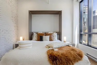 a bedroom with a large bed with a large window at Apartment MTL Dtown Spotlight MTL in Montréal